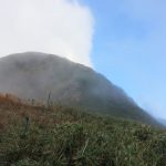 霧と雲が激しく流れ天気が目まぐるしく変わる中、雨飾山の山頂が見えてきた